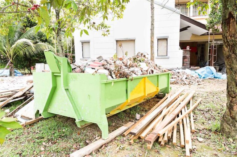 Construction debris collected in a large green dumpster as part of waste removal services Kent WA.